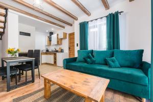 sala de estar con sofá verde y mesa en Malinowy Chruśniak Apartamenty, en Hoczew