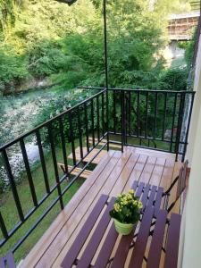 une terrasse couverte avec un banc et une plante en pot dans l'établissement Apartma Humar, à Tolmin