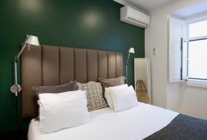 リスボンにあるFlats Castelo - HOrigemのベッドルーム1室(大型ベッド1台、白いシーツ、枕付)
