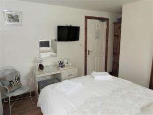 a bedroom with a white bed and a chair at West View Farm in Louth