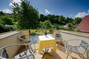 una mesa y sillas en un balcón con vistas en Hotel Garni Pod Skalkou, en Český Krumlov