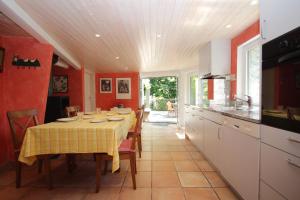 a dining room with a table and a kitchen at Casa Ilvea in Cavigliano