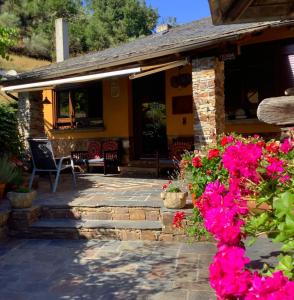 Ríodeporcos的住宿－Casa Rural Chao de Castro，庭院里鲜花粉红色的房子
