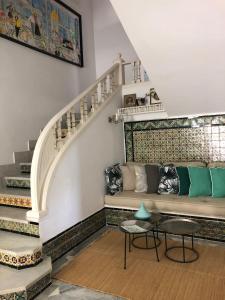 a living room with a couch and stairs at Dar Marsa Cubes in La Marsa