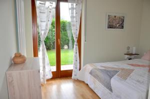 sypialnia z łóżkiem i drzwiami do podwórza w obiekcie Olive Garden w mieście Riva del Garda