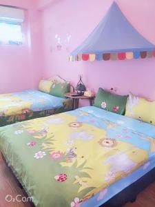 a bedroom with two beds with flowers on it at Hostel Summer Light in Green Island