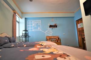 綠島鄉的住宿－燈光夏，一间卧室配有一张蓝色墙壁的床