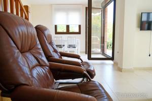 a brown leather reclining chair in a living room at Chalet Tina Mayor: amplio jardín y tranquilidad muy cerca de la playa in Pesués