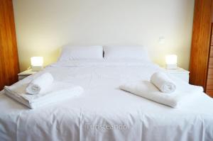 a white bed with towels on top of it at Chalet Tina Mayor: amplio jardín y tranquilidad muy cerca de la playa in Pesués