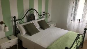 una camera da letto con letto a righe verdi e bianche di La dolce vita a Porto Recanati