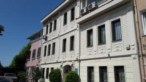 イスタンブールにあるマンガナ コナック ホテルの通りに多くの窓がある白い建物