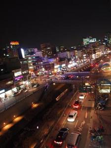 una strada trafficata di notte con macchine e luci di Cheonggye Haus a Seul