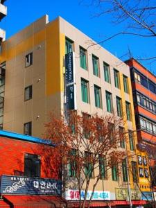 un edificio alto con un árbol delante de él en Cheonggye Haus en Seúl