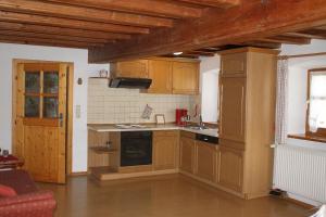 a kitchen with wooden cabinets and a stove top oven at Ferienhof Aiginger in Grafenau