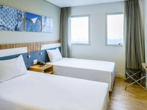 Tempat tidur dalam kamar di ibis Styles Confins Aeroporto