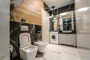 a bathroom with a toilet and a sink at Haris Luxury Apartment no.4 in Tirana +24 photos