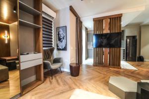 sala de estar con TV de pantalla plana y sofá en Haris Luxury Apartment no.4, en Tirana