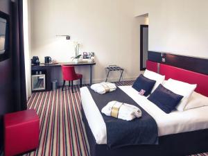 um quarto de hotel com uma cama grande e uma cabeceira vermelha em Mercure Angoulême Hôtel de France em Angoulême