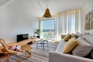 a living room with a couch and a tv at Apartamento Boavista - Sea View in Albufeira