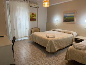 a hotel room with two beds and a chandelier at Casantica B&B Turismo Rurale in Milazzo