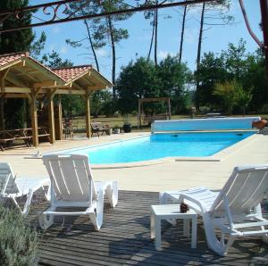 a group of white chairs and a swimming pool at LE GAHOUN - Chalet in Castets