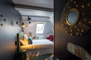 een slaapkamer met een bed en een spiegel aan de muur bij Hôtel - Restaurant Le Globe in Meursault