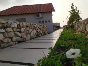 a stone retaining wall next to a house at נוריות בגלבוע 2 in Nurit
