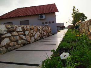 a stone retaining wall next to a house at נוריות בגלבוע 2 in Nurit
