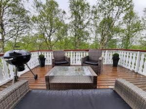 - un barbecue sur une terrasse avec des chaises et une table dans l'établissement Bungalow in Sirdal, à Tjørhom