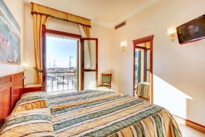 a bedroom with a large bed and a large window at Hotel Panorama in Venice-Lido