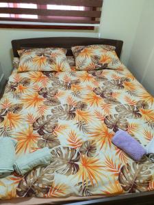 uma cama num quarto com uma colcha com flores em Apartman Petra em Nova Varos