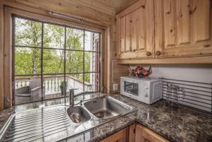 a kitchen with a sink and a microwave at Bungalow in Sirdal in Tjørhom