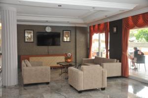 a living room with two chairs and a television at Marina Apart Hotel in Marmaris