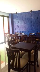 comedor con mesa, sillas y pared azul en Nalin Place, en Ranong