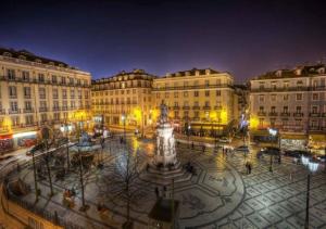 uma praça da cidade com uma estátua em frente aos edifícios em Bairro Alto Hotel em Lisboa