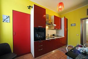 una cucina con armadi rossi e pareti gialle di Uno sguardo su Porta Palazzo by Wonderful Italy a Torino