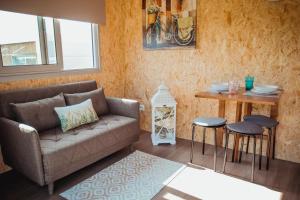 sala de estar con sofá y mesa con taburetes en MyStay - Bungalows in Quinta dos Sobrais en Valença