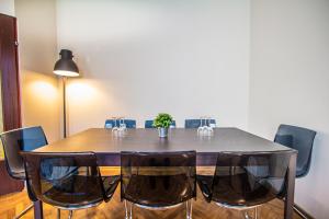 a dining room table with black chairs and a lamp at Apartment Enenkelstrasse in Vienna