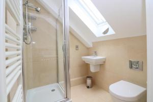 ein Badezimmer mit Dusche, Toilette und Waschbecken in der Unterkunft Beachside apartment, sea views in Saint Merryn