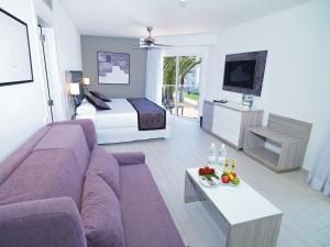 a living room with a couch and a bed at Hotel Riu Palace Meloneras in Maspalomas