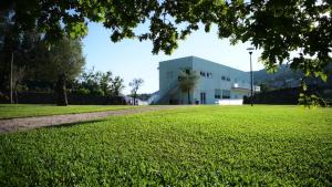 un edificio blanco en un campo de césped verde en Funileiro, apartamentos e quartos en Amares