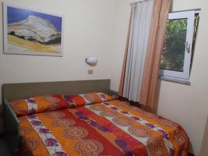 een slaapkamer met een bed en een raam bij Appartamento panoramico Calarossa Sardegna in Isola Rossa