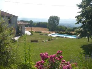 a view of a yard with a pool and flowers at Les Garennes in Saint-Uze