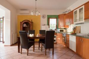 a kitchen with a wooden table and black chairs at Komfort Apartma ob Parenzani - Paremzana Confort Apartment in Izola