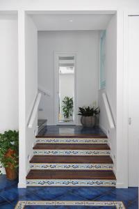 a hallway with stairs with blue and white tiles at Residence Panoramic in Maiori