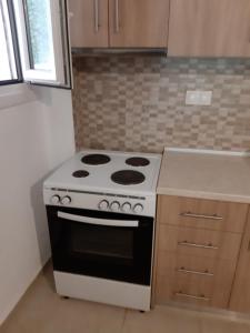 a kitchen with a stove and a counter top at Maria Lemoni swimming pool apartment in Nea Skioni