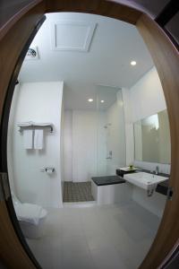 a bathroom with a sink and a toilet and a mirror at Winstar Hotel in Pekanbaru