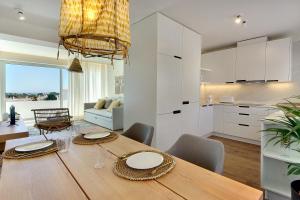 una cucina e una sala da pranzo con tavolo e sedie in legno di Apartamento Boavista - Sea View ad Albufeira