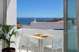 un tavolo e sedie su un balcone con vista sull'oceano di Apartamento Boavista - Sea View ad Albufeira