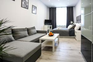 a living room with a couch and a bed at Cracow by Night Apartments in Krakow
